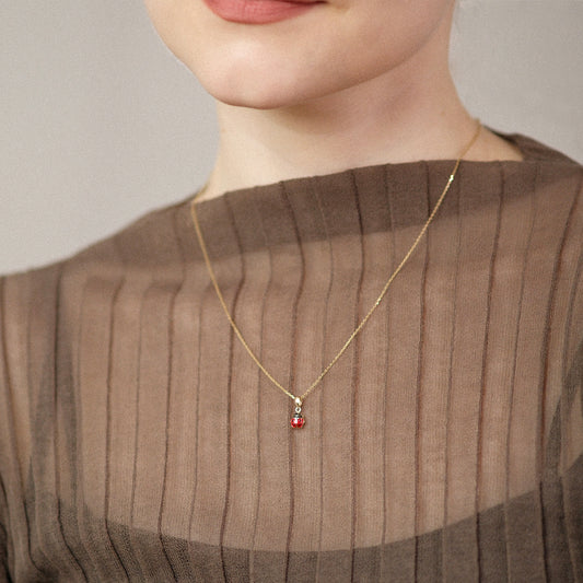 Model trägt eine Kette mit Marienkäfer-Anhänger aus 14k Echtgold.