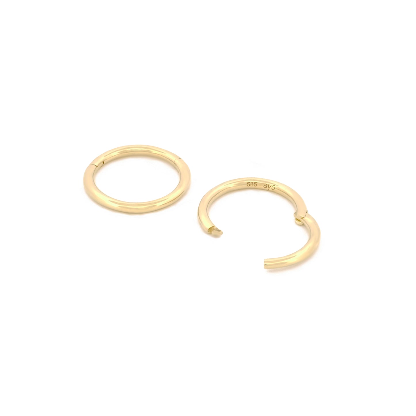 Detailansicht Verschluss des Seamless Huggie Hoops aus 14k Gelbgold, liegend auf weißem Hintergrund.