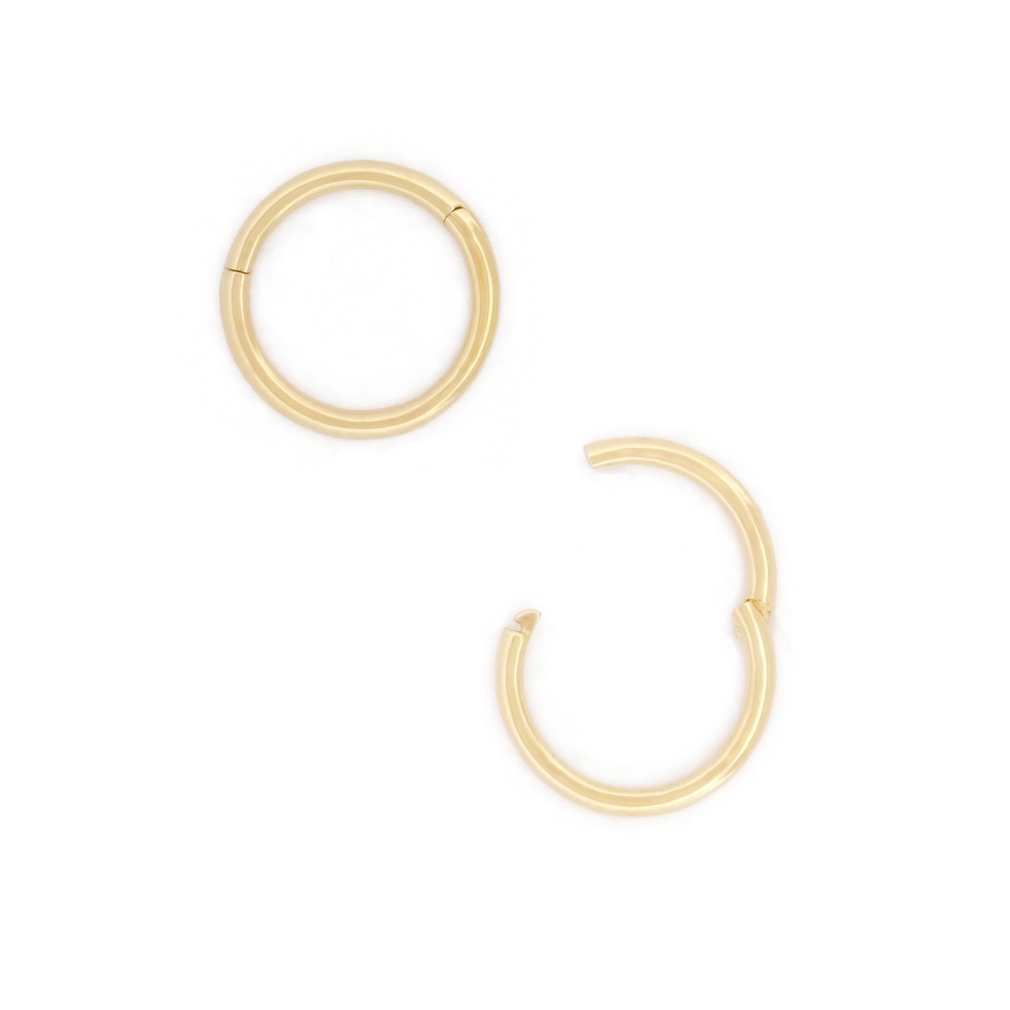 Detailansicht Öffnungsweite des Seamless Huggie Hoops aus 14k Gelbgold, liegend auf weißem Hintergrund.