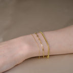 Handgelenk mit drei Armketten aus 14k Echtgold der Marke ayu – Essential Anchor Bracelet, Paperclip Bracelet & Curb Bracelet.