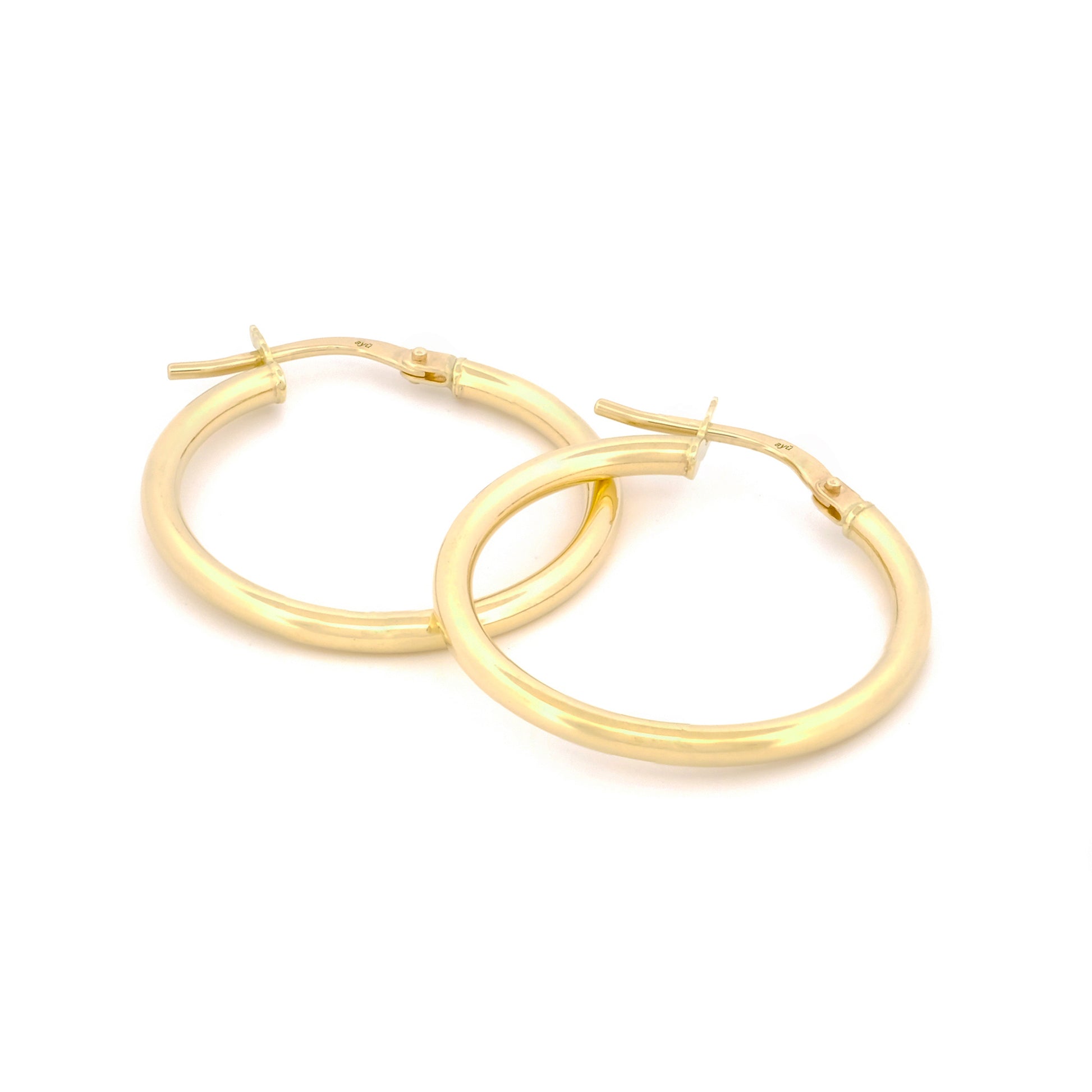 Classic Hoops in Größe L aus 14k Gelbgold liegen auf weißem Hintergrund.