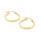 Classic Hoops in Größe M aus 14k Gelbgold liegen auf weißem Hintergrund.
