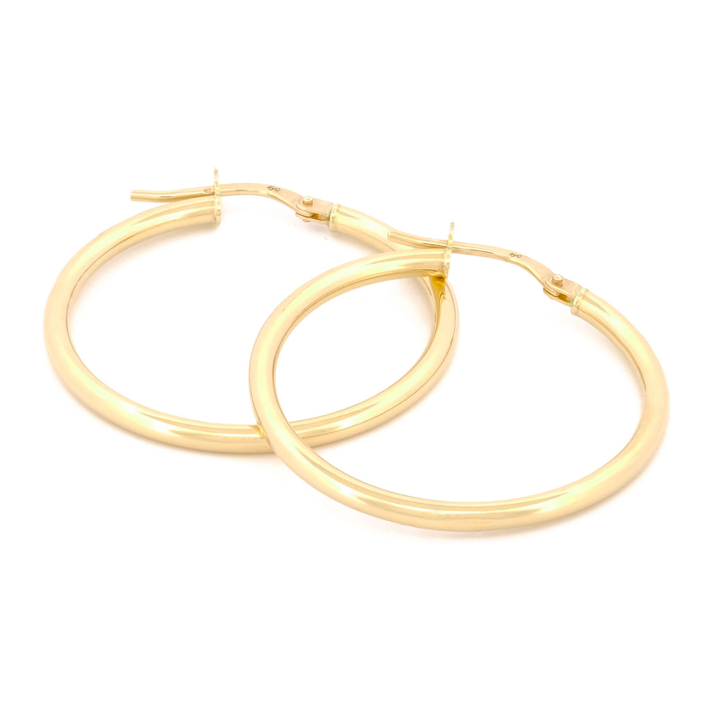 Classic Hoops in Größe XL aus 14k Gelbgold liegen auf weißem Hintergrund.
