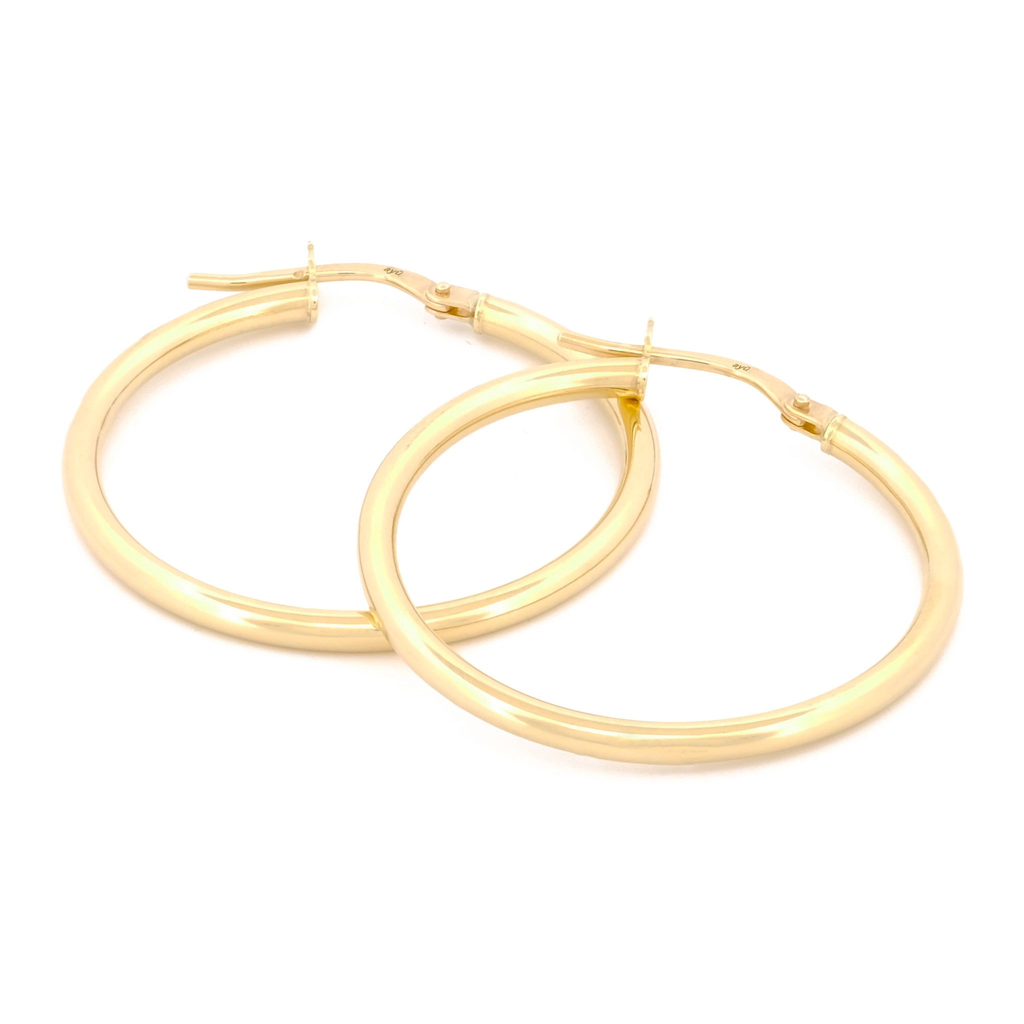 Classic Hoops in Größe XL aus 14k Gelbgold liegen auf weißem Hintergrund.