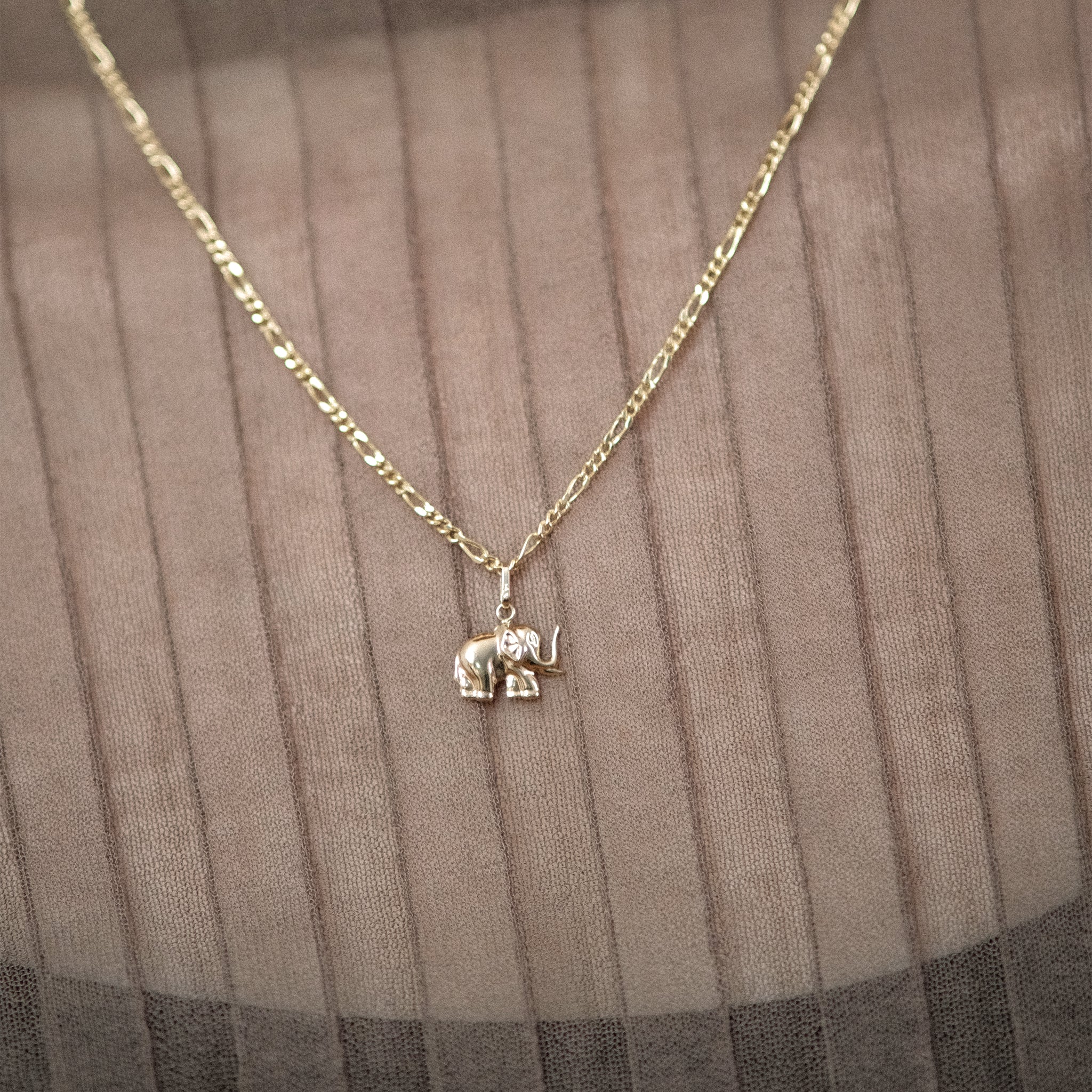 Model trägt eine Figarokette mit Elefant-Anhänger aus 14k Echtgold.
