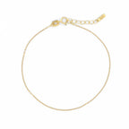 Filigranes Anker-Armband aus 14k Gelbgold vor weißem Hintergrund.