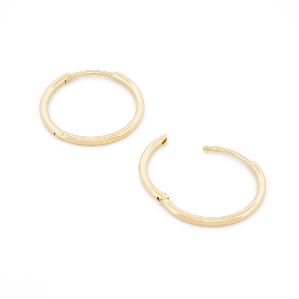 Detailansicht Verschluss des filigranen Essential Hoops aus 14k Gelbgold, liegend auf weißem Hintergrund.