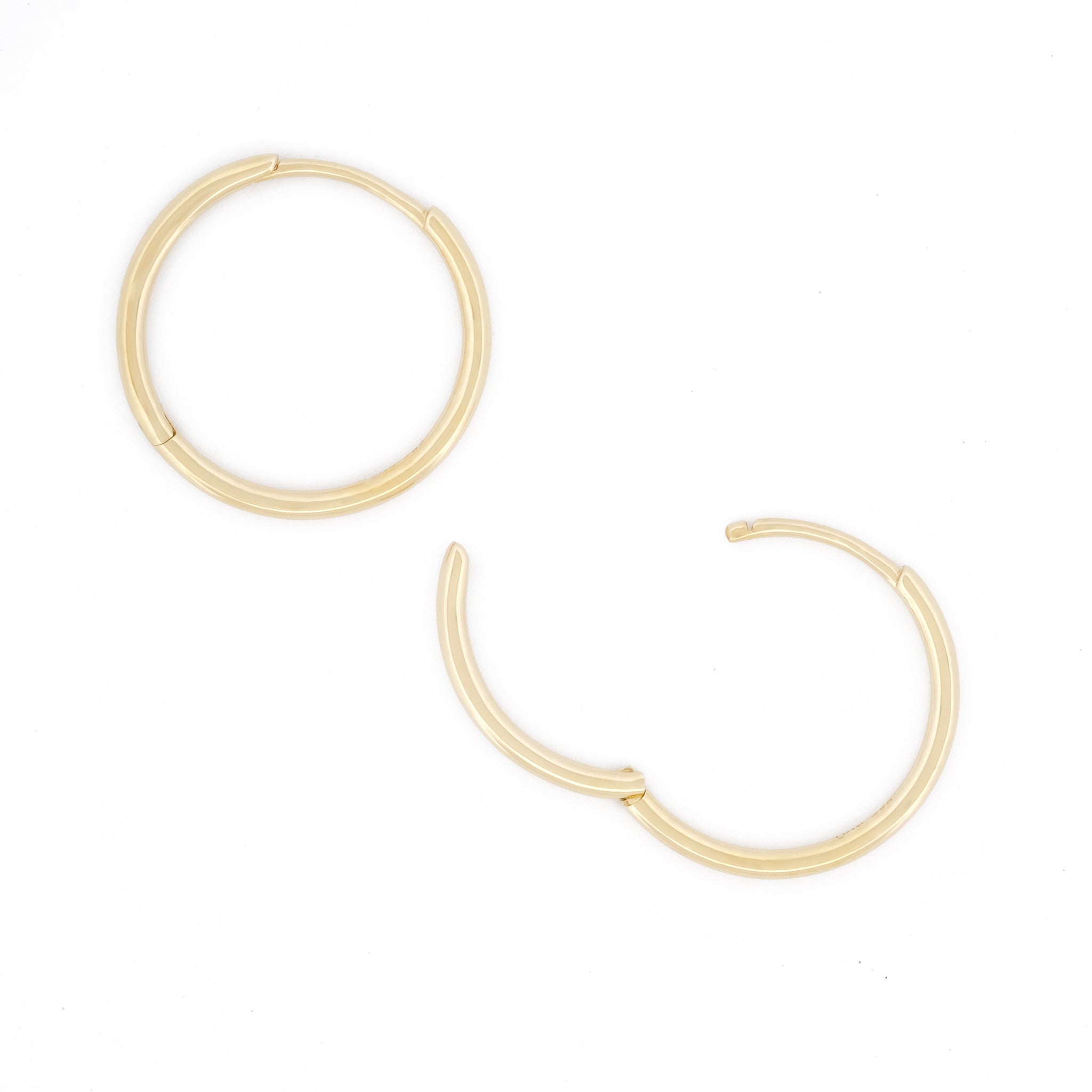 Detailansicht Öffnungsweite des filigranen Essential Hoops aus 14k Gelbgold, liegend auf weißem Hintergrund.