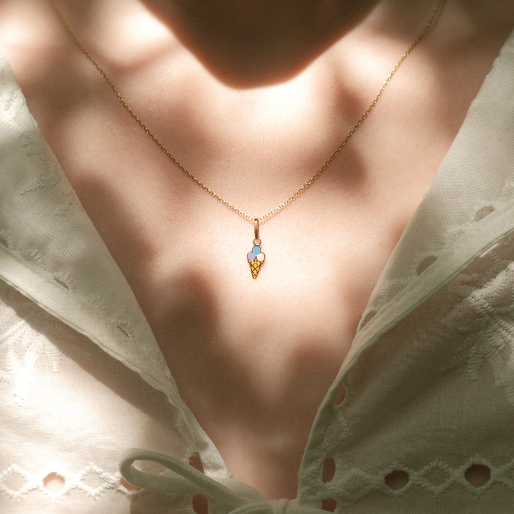 Eis-Anhänger aus 14k Massivgold an einer feinen Kette getragen zu weißem Spitzenoberteil.