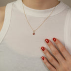 Model trägt eine Kette mit Marienkäfer-Anhänger aus 14k Echtgold über weißem Top.