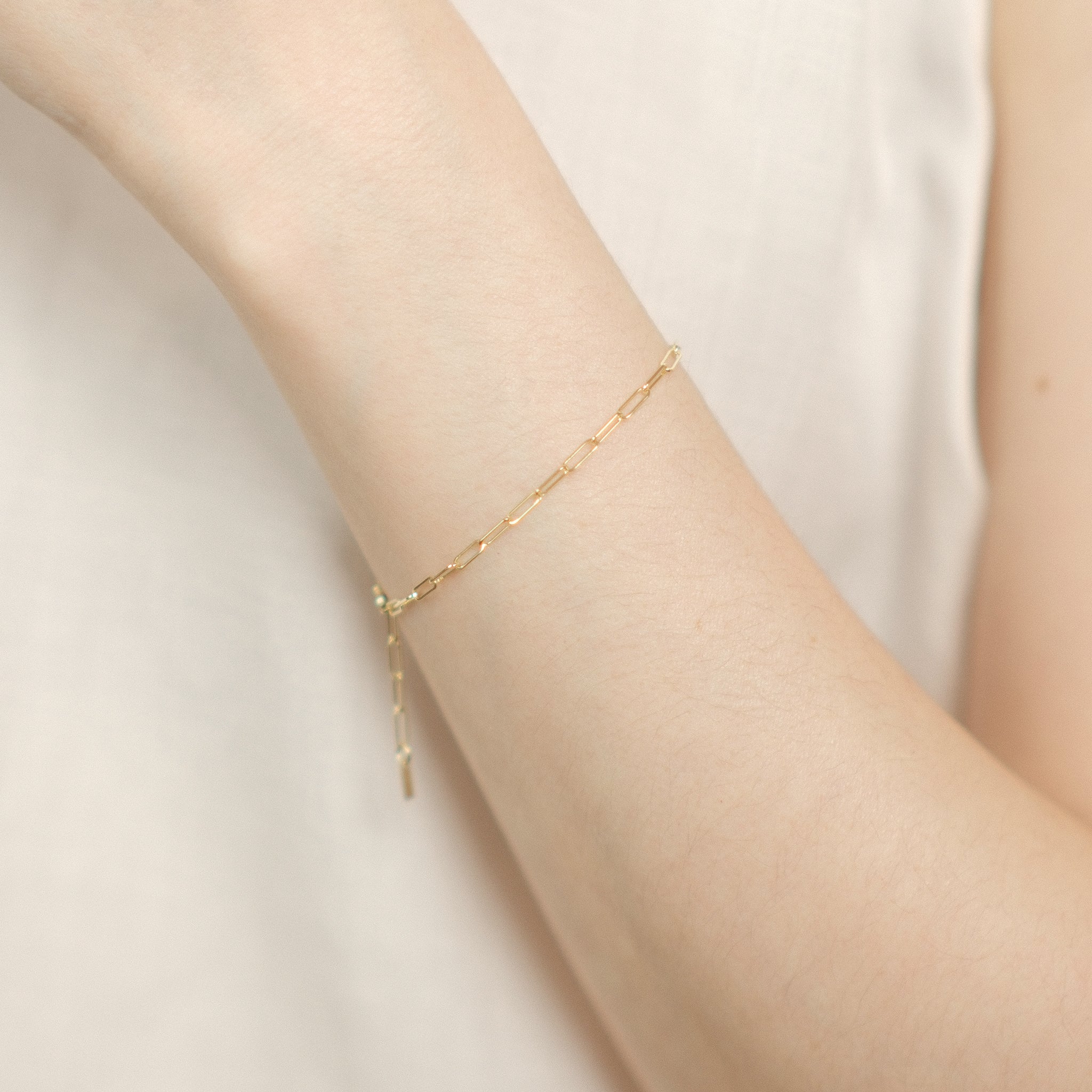 Model trägt elegantes Paperclip-Armband aus 14k Gold.