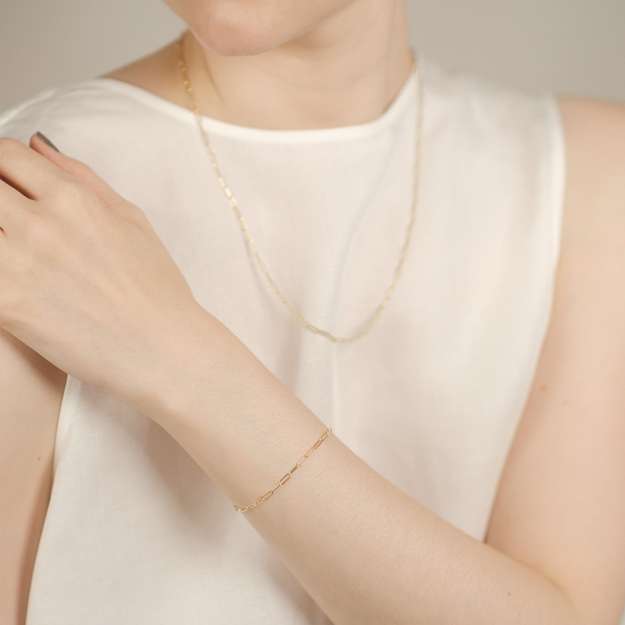 Model trägt elegantes Paperclip-Armband aus 14k Gold mit der passenden Halskette.