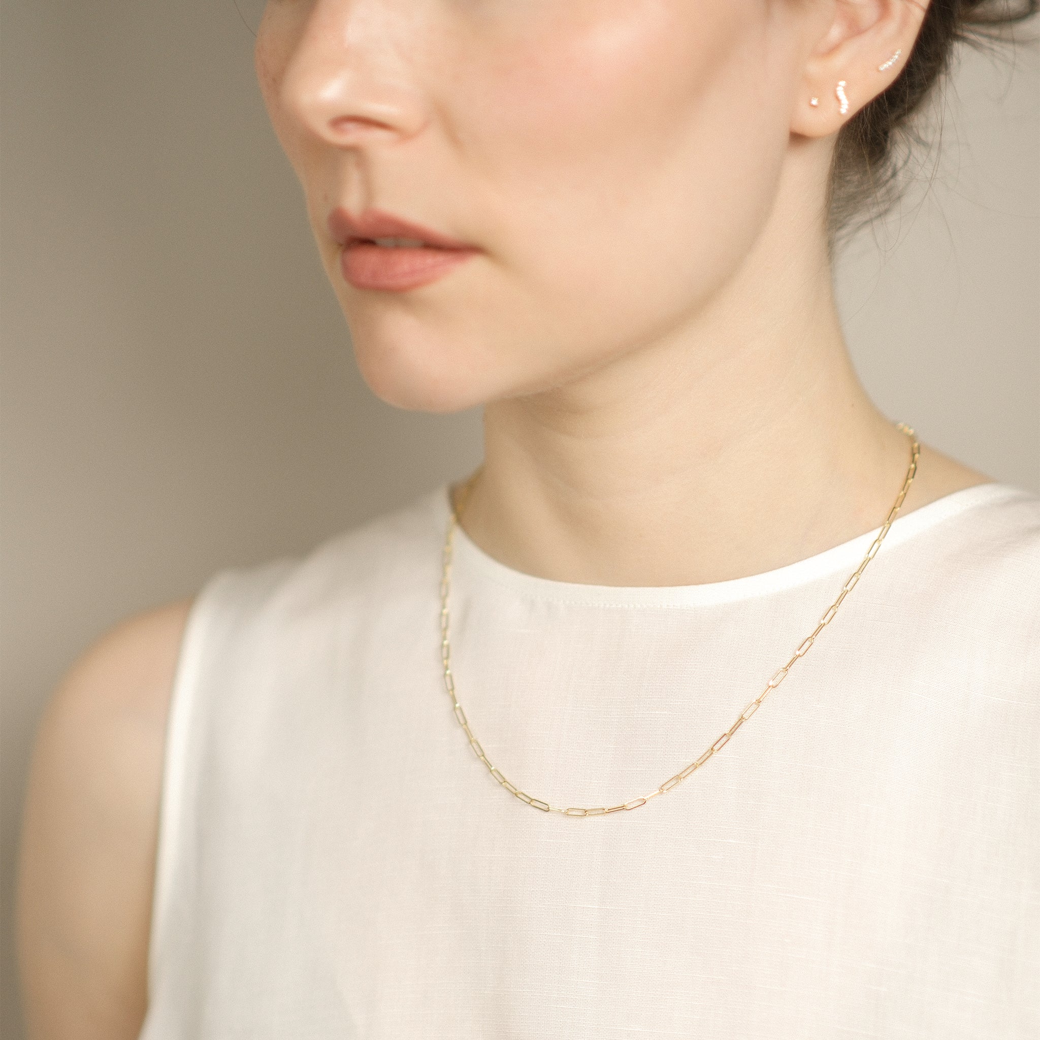 Model trägt elegante Paperclip-Kette aus 14k Gold.