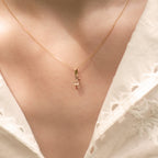 Flamingo-Anhänger aus 14k Massivgold an filigraner Goldkette getragen zu weißer Spitzenbluse.
