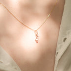 Flamingo-Anhänger aus 14k Massivgold an einer feinen Kette getragen im sommerlichen Licht.