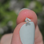 Ohrstecker aus 14k Gelbgold und drei Diamanten funkelt im Sonnenlicht.