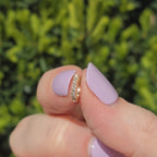 Kleiner Ohrring aus 14k Gelbgold und 18 Diamanten funkelt im Sonnenlicht.