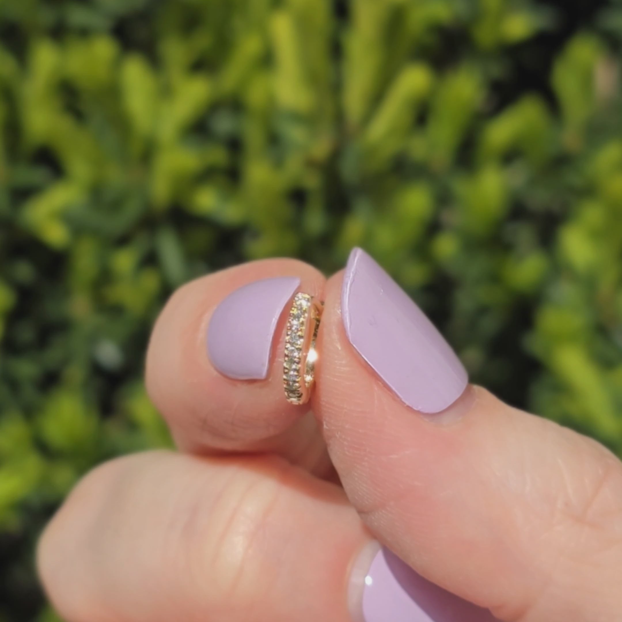 Kleiner Ohrring aus 14k Gelbgold und 18 Diamanten funkelt im Sonnenlicht.